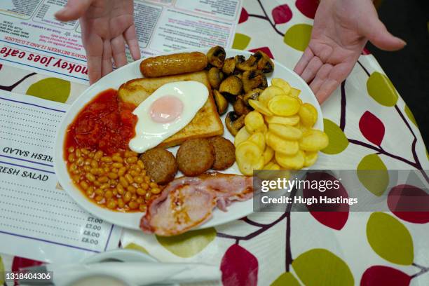 Early-morning full English Breakfast is served at an indoor table at Smokey Joe's Cafe, Scorrier, on May 17, 2021 in Falmouth, England. England...