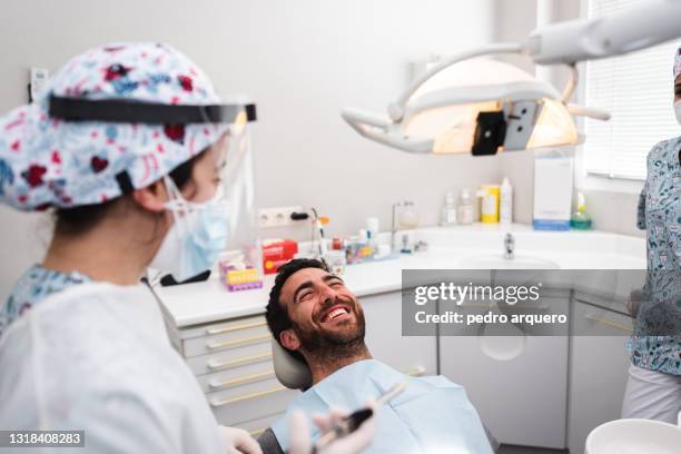 dentist and assistant talking to the patient before his revision - dental office bildbanksfoton och bilder