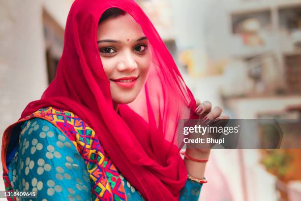 beautiful indian young woman standing at balcony in fresh air and contemplating. - salwar kameez stock pictures, royalty-free photos & images