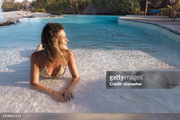 gelukkige vrouw die in de zomerdag bij het zwembad geniet. - shallow stockfoto's en -beelden
