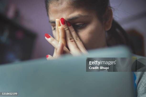 beklemtoonde vermoeide jonge vrouw die laptop gebruikt om van huis te werken. - cyberbullying stockfoto's en -beelden