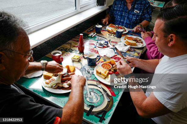 Table of customers are served full English Breakfasts at an indoor table at Jenn's Diner, Redruth, on May 17, 2021 in Falmouth, England. England...