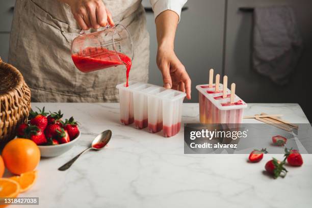 llenado de mezcla de helados líquidos en moldes - ice lolly fotografías e imágenes de stock