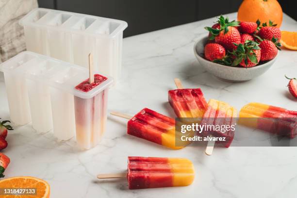 paletas de hielo de fresa de naranja congelada - amoldar fotografías e imágenes de stock