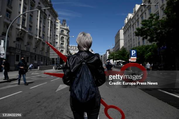 Person of the aesthetics sector stands with some giant scissors at a demonstration organized from the Paseo del Prado to the Congress of Deputies, on...