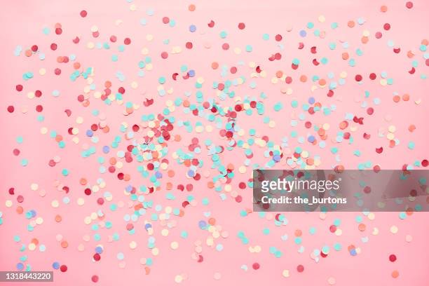 full frame shot of multi colored confetti on pink background - party konfetti stock-fotos und bilder