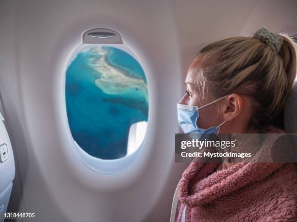 woman traveling by plane during coronavirus pandemic - quarantine travel stock pictures, royalty-free photos & images