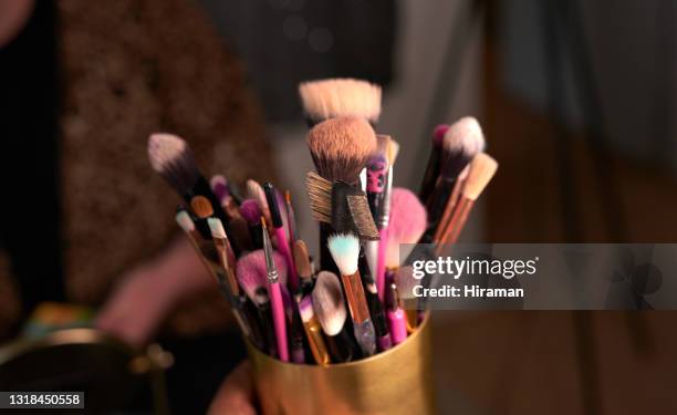 schuss von make-up bürsten in einem behälter auf einem tisch backstage - schminkpinsel stock-fotos und bilder