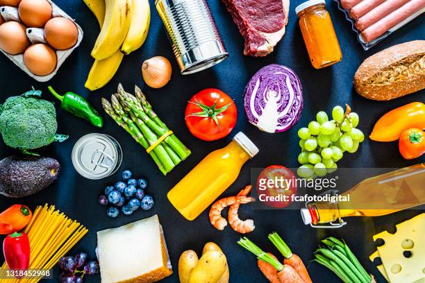 grote verscheidenheid van voedsel op zwarte achtergrond - fruits table top stockfoto's en -beelden