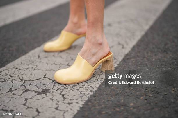 Natalia Verza @mascarada.paris wears pale pastel yellow block wooden heels shoes / mules from Miista, on May 16, 2021 in Paris, France.