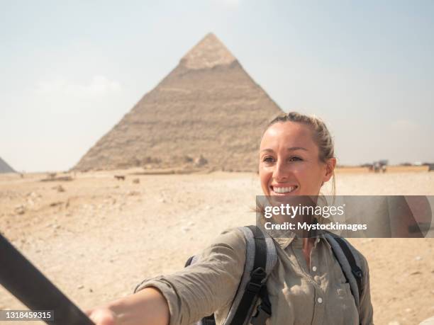 frau macht selfie an den pyramiden in ägypten, sie verwendet eine action-kamera - selfiestick stock-fotos und bilder