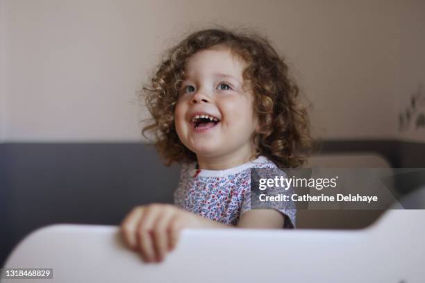 a 2 year old girl smiling in her cradle - 2 year old child fotografías e imágenes de stock