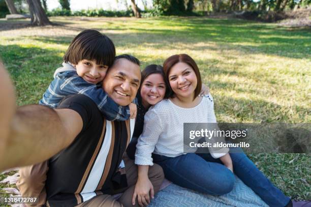 lateinischer vater macht selfie mit familie draußen - latin father and son stock-fotos und bilder