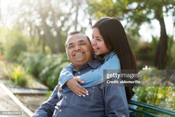 gelukkige latijnse vader en dochter die van tijd bij park genieten - happy smiling family stockfoto's en -beelden