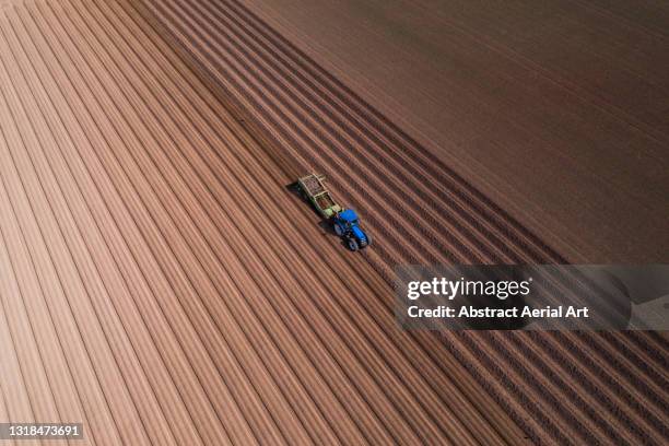 high angle perspective showing a tractor working in a plowed field, england, united kingdom - champs tracteur photos et images de collection