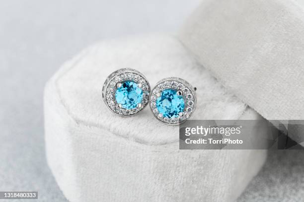 silver stud earrings with blue gemstone in white jewelry box - topaz fotografías e imágenes de stock