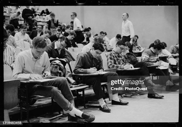 View of large group of students as they take an exam in a lecture hall at the University of Maryland, College Park, Maryland, January 28, 1964.