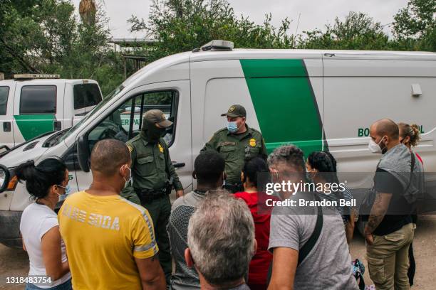 Immigrants prepare to be taken to a border patrol processing facility after crossing the Rio Grande river into the United States on May 17, 2021 in...