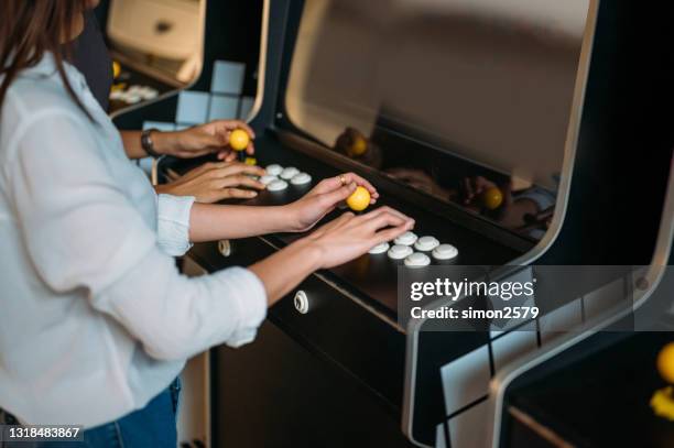 employees playing arcade game on games room at the co-working office during break - joystick stock pictures, royalty-free photos & images