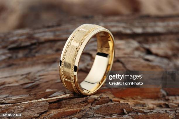 modern gold textured wedding ring on natural wood background - ring stock-fotos und bilder