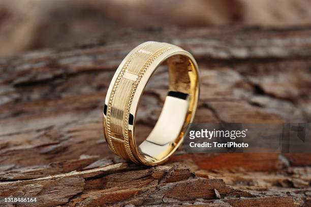 modern gold textured wedding ring on natural wood background - gold meets golden fotografías e imágenes de stock