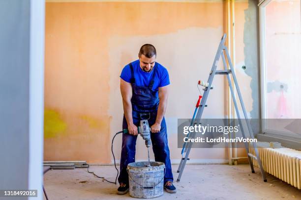 uomo che prepara vernice e intonaco per la pittura murale - robot da cucina foto e immagini stock