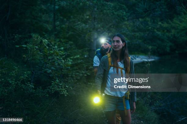 couple exploring the woods through the night - flashlight imagens e fotografias de stock