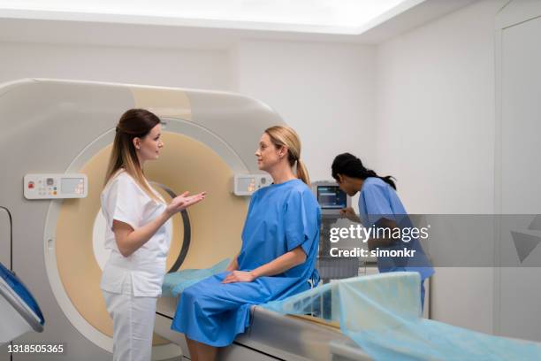 mature woman talking with a doctor before cat scan - x ray highlighted stock pictures, royalty-free photos & images