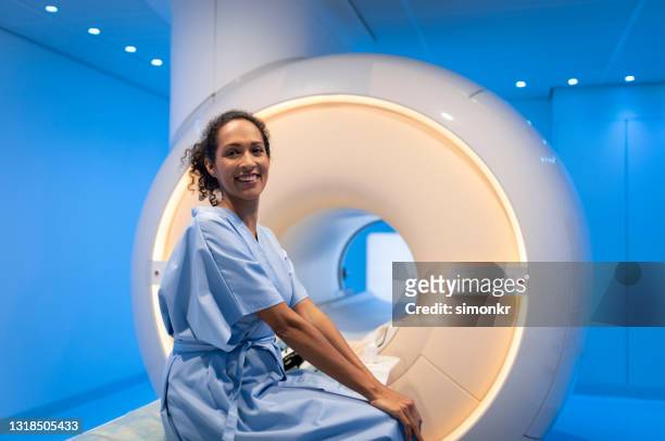 patientin sitzt vor der mrt-scan auf dem bett - magnetresonanztomographie stock-fotos und bilder