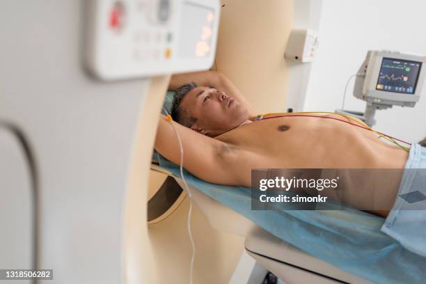 mature man being slid into the cat scanner - scientific imaging technique stock pictures, royalty-free photos & images