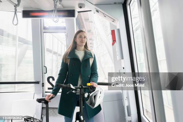 female commuter with folding bike on skytrain - folding bike stockfoto's en -beelden