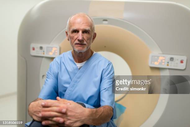 senior male patient sitting on bed before a cat scan - cancer patient portrait stock pictures, royalty-free photos & images