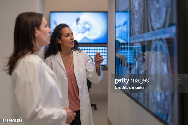 female radiologists analysing the mri images on the lightbox - radiologist stock pictures, royalty-free photos & images