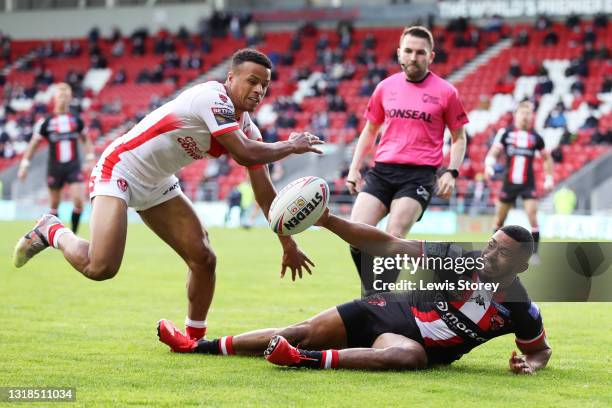 Kallum Watkins of Salford Red Devils is tackled by Regan Grace of St Helens during the Betfred Super League match between St Helens and Salford Red...