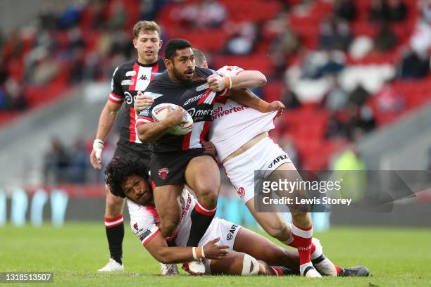 Seb Ikahihifo of Salford Red Devils is tackled by Agnatius Paasi and Kyle Amor of St Helens during the Betfred Super League match between St Helens...