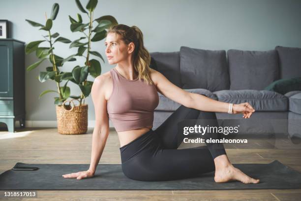 mujer en ropa deportiva haciendo deportes en casa - exercising fotografías e imágenes de stock