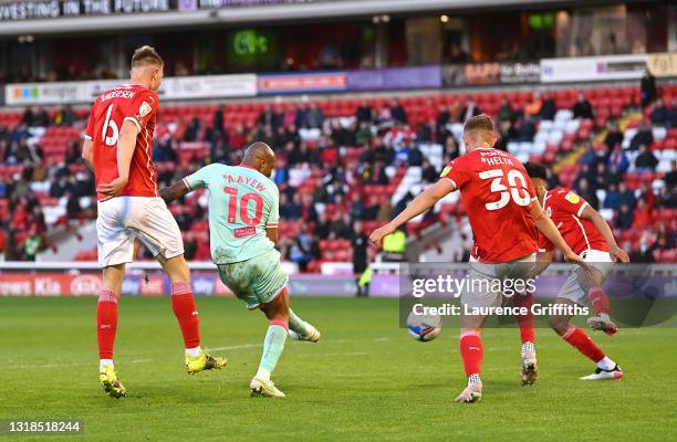 Andre Ayew of Swansea City scores his team's first goal while under pressure from Mads Juel Andersen and Michal Helik of Barnsley FC during the Sky...