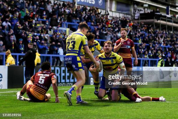Daryl Clark of Warrington Wolves celebrates with team mates after scoring their side's second try during the Betfred Super League match between...