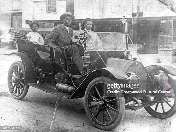 View of American businessman John Wesley Williams sits in his car with wife Loula Williams and their son, WD Williams, Tulsa, Oklahoma, 1910s.