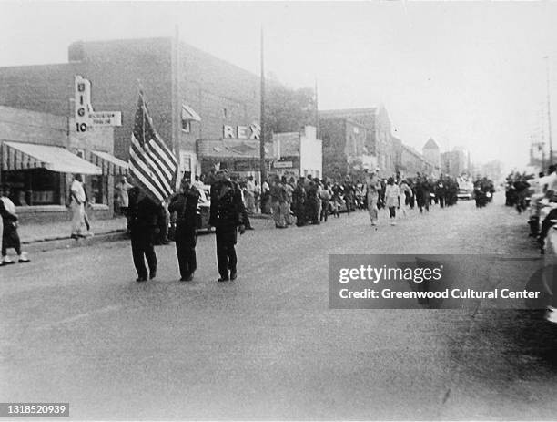 View of an unspecified parade on Greenwood Avenue, Tulsa, Oklahoma, early twentieth century. Among the visible businesses is the Rex Theater .