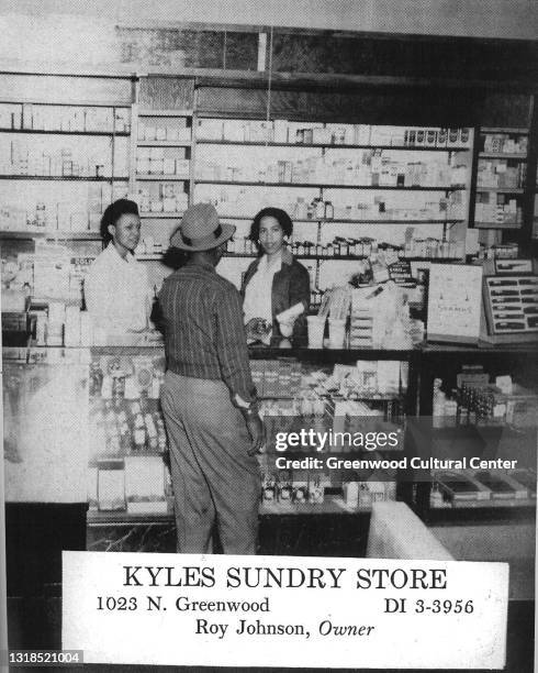 Interior view of Kyles Sunday Store as sales clerks assist a customer at a pharmacy counter, Tulsa, Oklahoma, 1940s or 1950s.