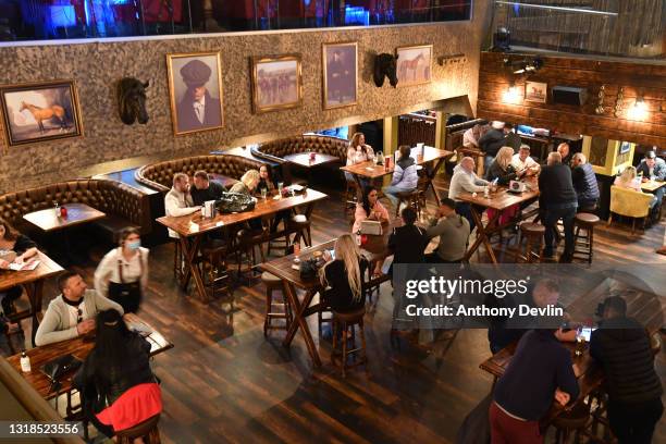 Patrons enjoy a drink at the Peaky Blinders bar in the city centre on May 17, 2021 in Manchester, England. From today, pandemic-inspired restrictions...