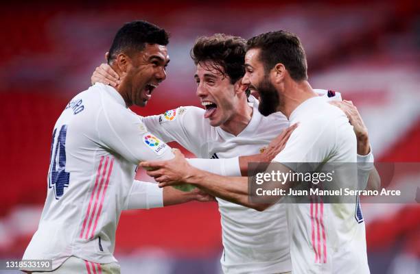 Nacho Fernandez of Real Madrid celebrates with his teammate Carlos Casemiro and Alvaro Odriozola of Real Madrid after scoring the opening goal during...