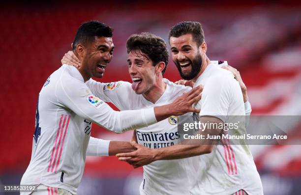 Nacho Fernandez of Real Madrid celebrates with his teammate Carlos Casemiro and Alvaro Odriozola of Real Madrid after scoring the opening goal during...