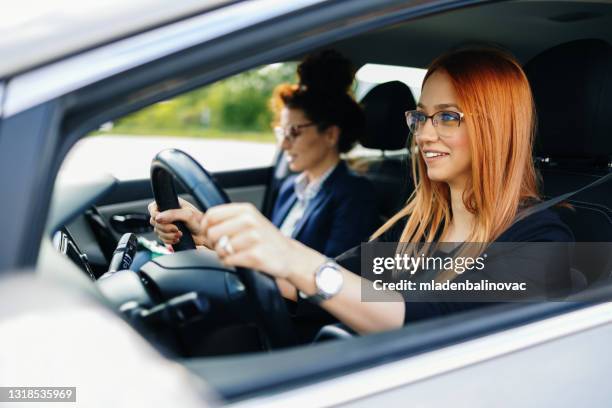 運転学校やテスト。美しい若い女性は、彼女のインストラクターと一緒に車を運転する方法を学ぶ。 - learning to drive ストックフォトと画像