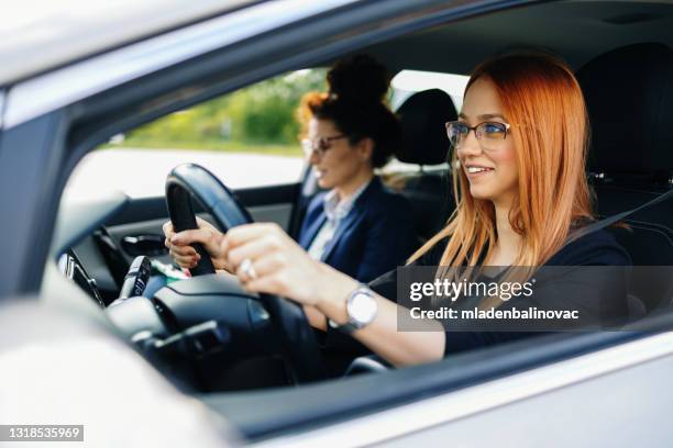 driving school or test. beautiful young woman learning how to drive car together with her instructor. - driving instructor stock pictures, royalty-free photos & images