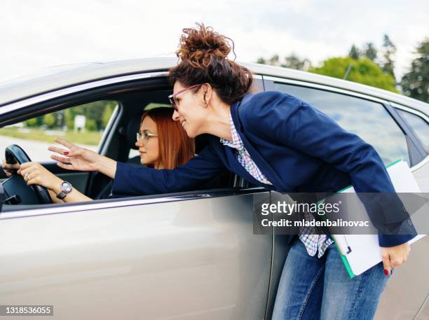 fahrschule oder prüfung. schöne junge frau lernen, wie man auto fahren zusammen mit ihrem lehrer. - erlaubt stock-fotos und bilder