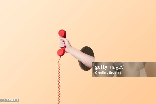 hand holding a phone - landline phone imagens e fotografias de stock