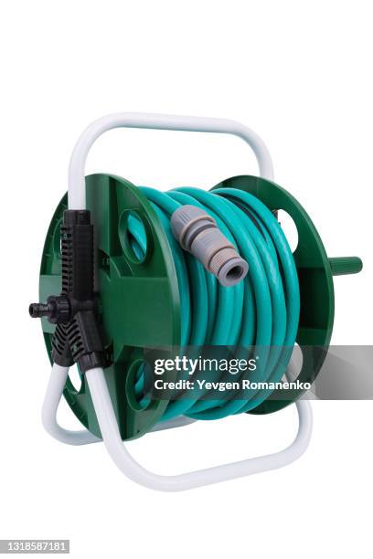 garden watering hose on a reel isolated on white background - tuinslang stockfoto's en -beelden