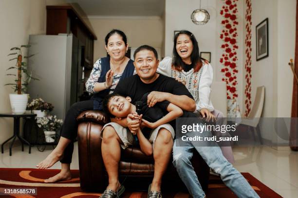 asiatische familie singen karaoke lachen und genießen alle zusammen im wohnzimmer seines hauses - chubby asian girl stock-fotos und bilder